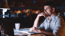 Man-working-on-laptop-at-night-in-office